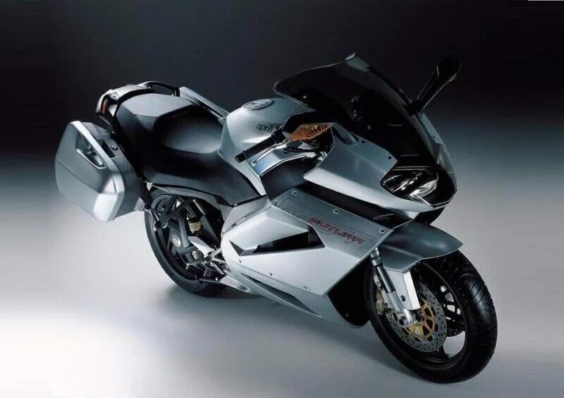 <div class='descrGalleryTitle'>RST 1000 Futura</div><div class='descrGalleryText'><p>Prodotta dal 2001 al 2004, l'Aprilia RST 1000 Futura è una sport-touring equipaggiata con il motore <b>Rotax bicilindrico a V di 998 cc </b>sviluppato per la RSV Mille, abbinato ad un pregevole telaio perimetrale in alluminio e forcellone monobraccio; aveva soluzioni interessanti come la carena molto estesa e le borse laterali integrate, e <b>prometteva prestazioni brillanti e grande comfort </b>sulle lunghe distanze.&nbsp;Nonostante queste premesse, come <a href="https://www.dueruote.it/news/moto-scooter/2023/11/12/le-moto-incomprese.html">la sorella SL 1000 Falco</a> la Futura non ha riscosso il successo commerciale atteso, e le ragioni sono molteplici. Un design originale e futuristico, ma che non ha incontrato il favore del pubblico, risultando troppo spigoloso; e <b>la temibile concorrenza della Honda VFR, </b>vera dominatrice del segmento col suo inarrivabile mix migliore tra prestazioni, comfort e affidabilità. Senza contare che Aprilia si stava allora affacciando per la prima volta nel mondo delle maxi, con tutte le le incognite circa la rete di assistenza e la <b style="font-size: 0.8125rem; background-color: transparent;">reperibilità dei ricambi</b>, non all'altezza delle case giapponesi a fronte&nbsp;di un prezzo di vendita piuttosto elevato. Anche oggi mettersi in garage un’Aprilia RST 1000 Futura rappresenta un’incognita proprio per l’ultima ragione: è affetta da problemi ricorrenti, quali la breve vita del cuscinetto del mozzo posteriore, e il ricambio è sempre più difficile da trovare. Un peccato, perché da guidare era una gran bella moto.</p>
</div>