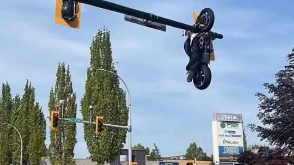 Meglio che al circo! Un uomo in Suzuki si schianta con una BMW, la sua moto schizza in aria e resta appesa al palo del semaforo